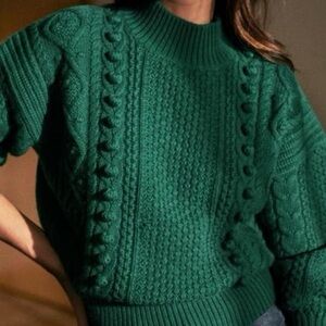 Sézane Amaury Aran-style cable knit sweater in an emerald green color.